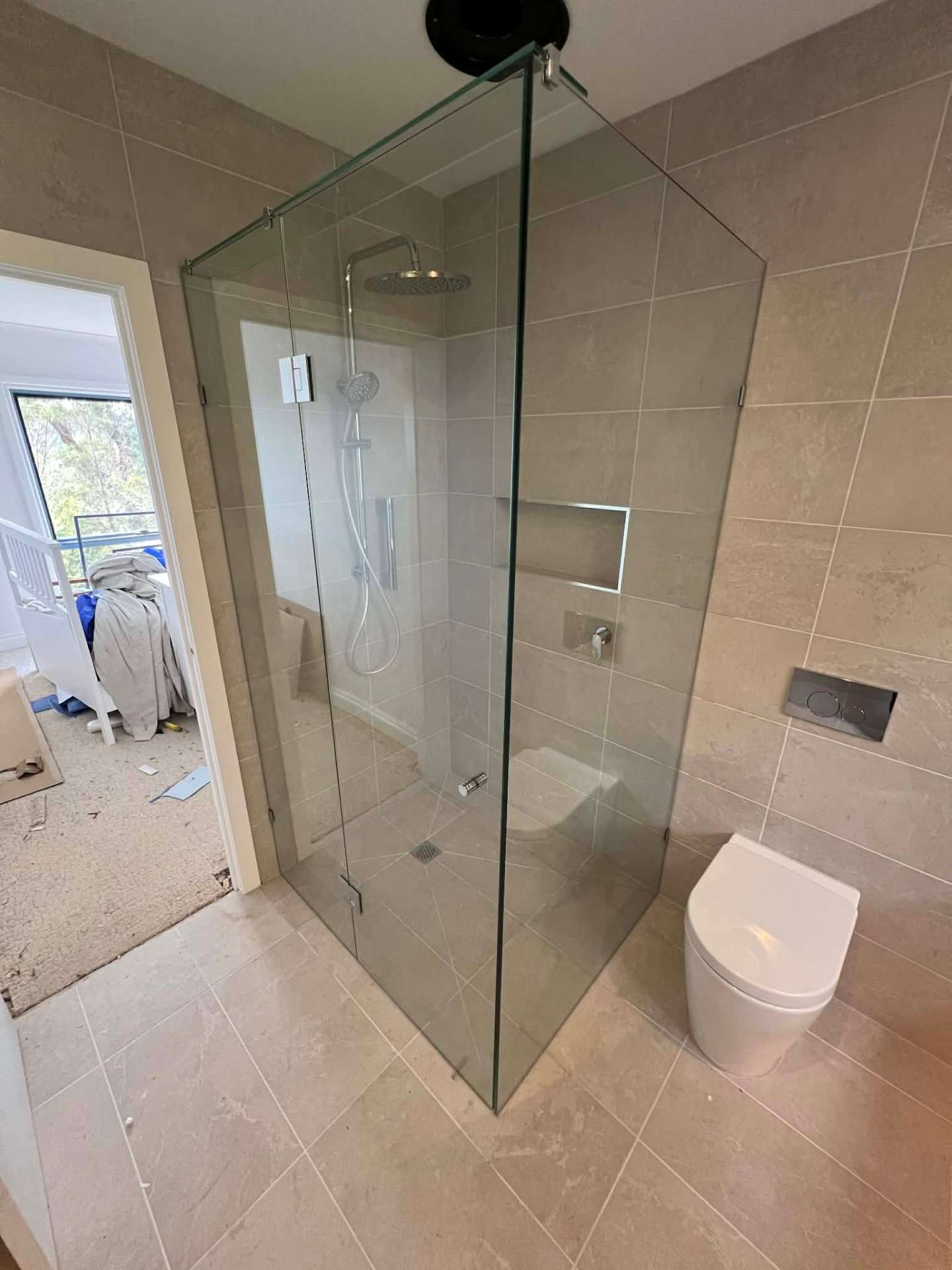 Frameless corner shower enclosure with hinged door