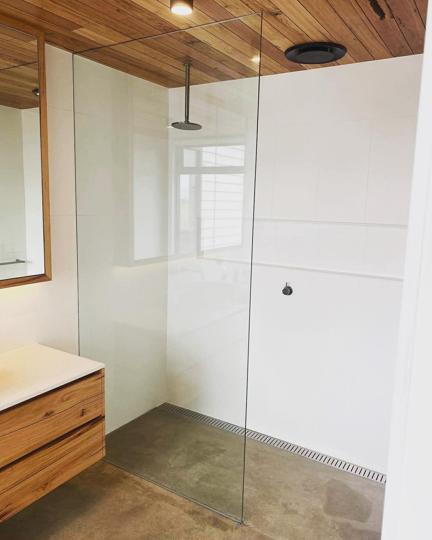 Frameless walk-in shower panel with timber ceiling