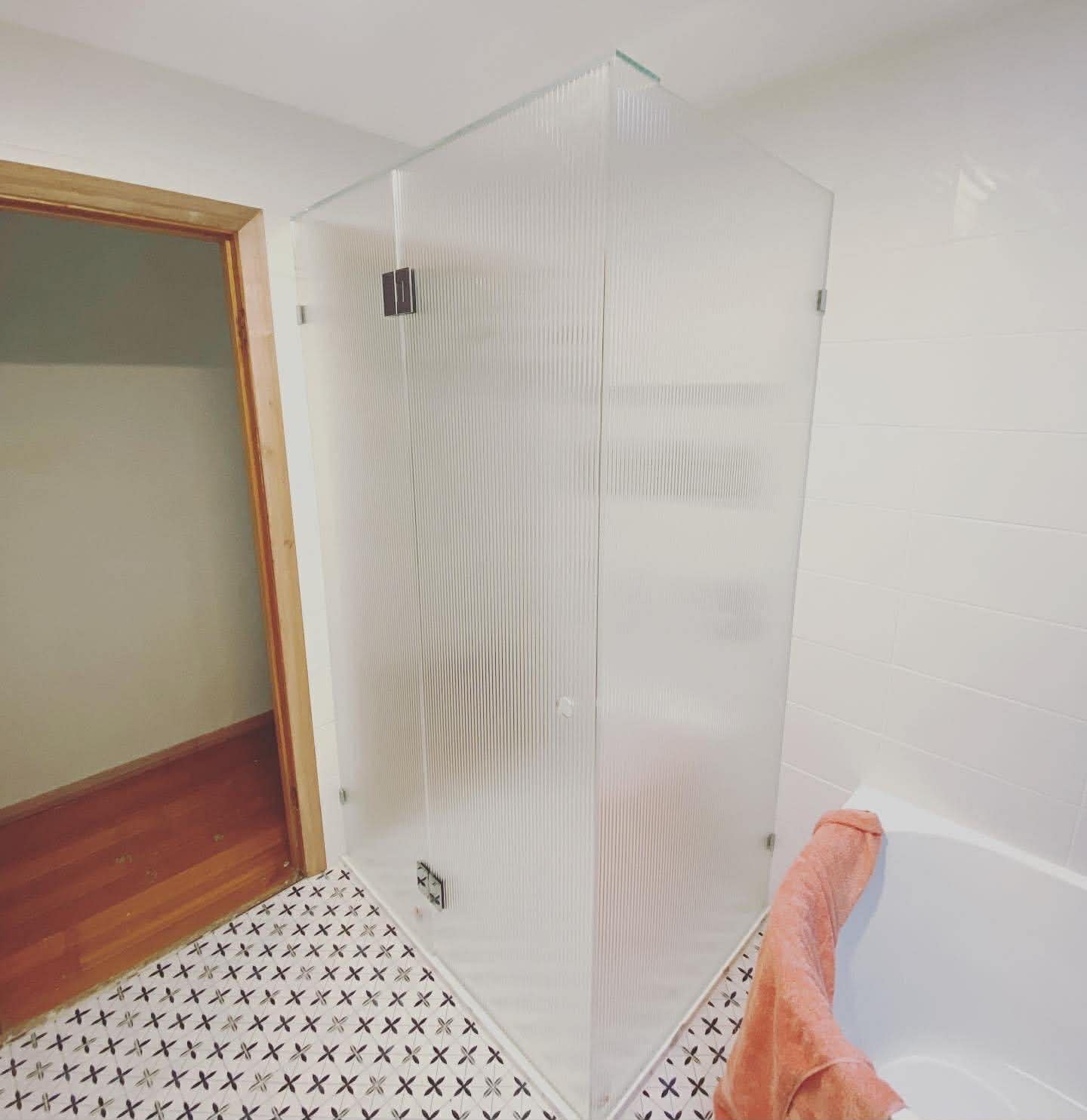 Frameless fluted glass corner shower enclosure