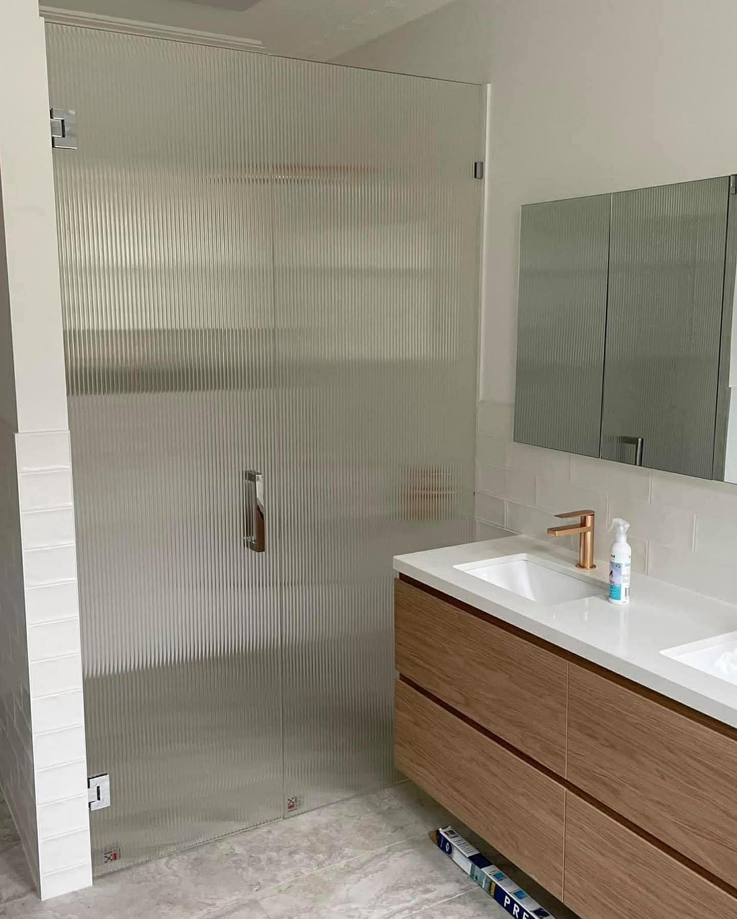 Frameless fluted glass shower door with chrome handle