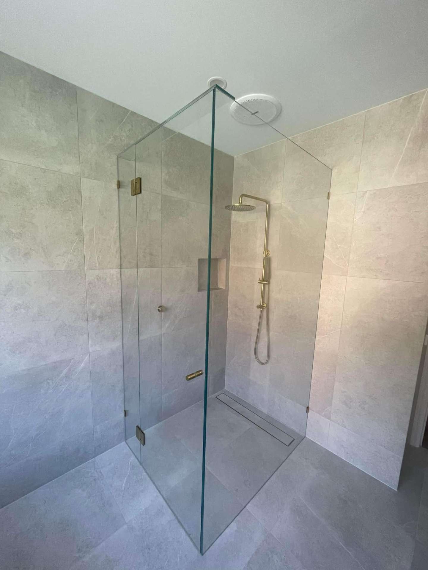 Frameless corner shower with gold hinges